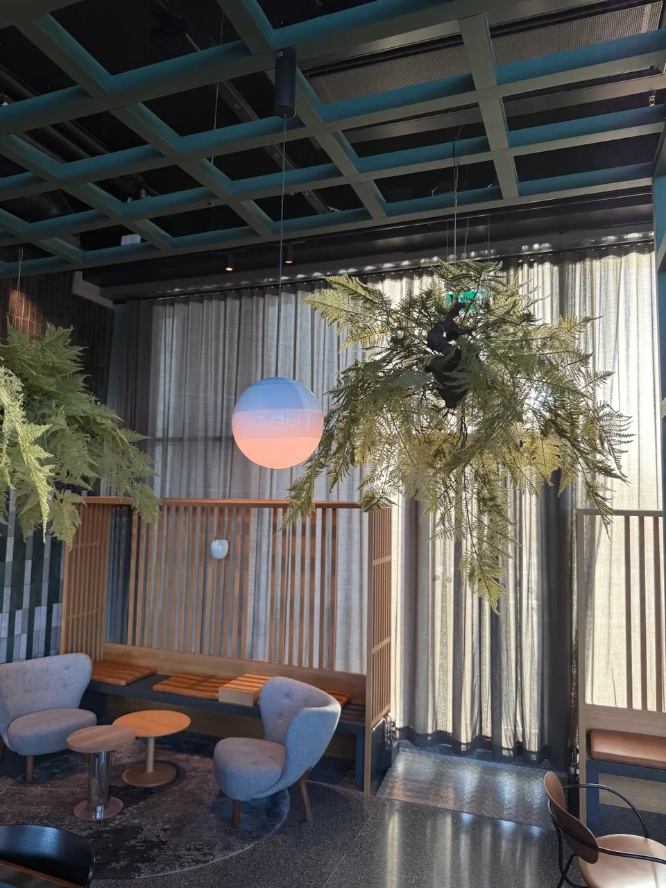Custom round glass pendant shade installed in an airport hotel lounge lighting project