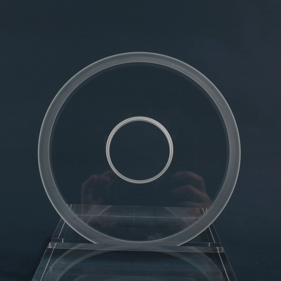 Clear circular glass disc standing upright with a stepped rim and central opening