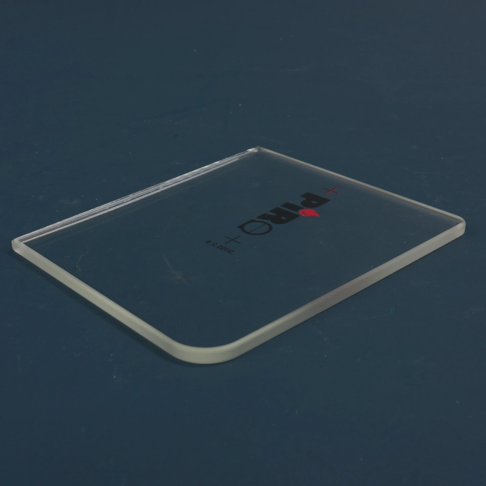 Clear rectangular glass panel with a small printed mark lying diagonally