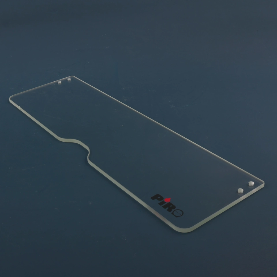 Long clear glass panel with an angled outline detail and small printed marks