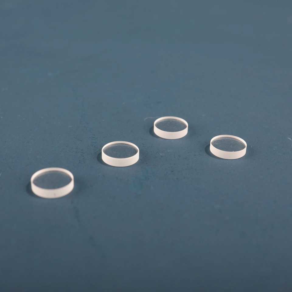 Small clear circular glass lenses arranged on a blue background