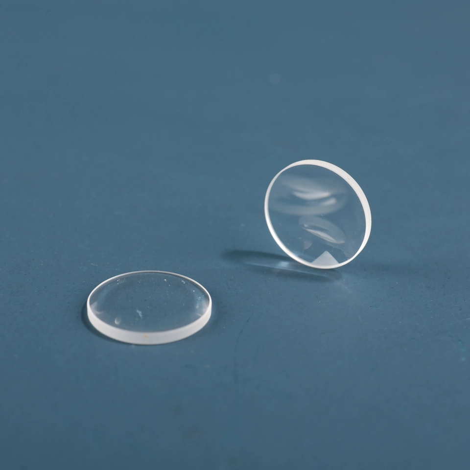 Two clear shallow domed glass lenses shown at different angles on a blue background