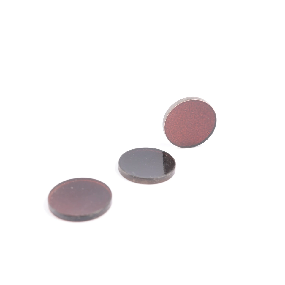 Three tinted glass discs with one disc standing behind two horizontal discs